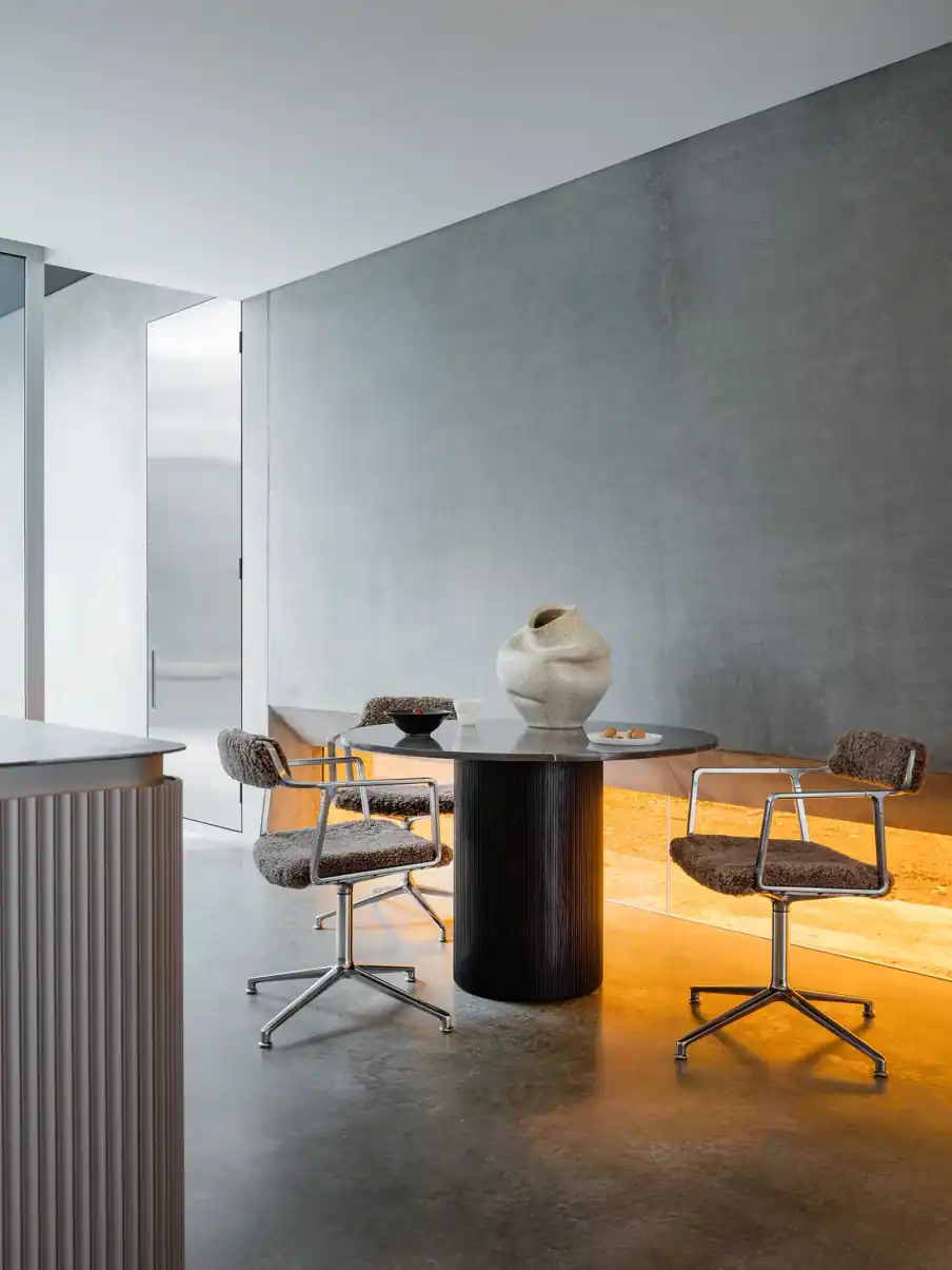 Dining area with Vipp chairs around a round black table