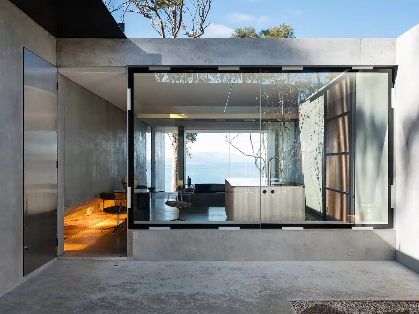 View across the atrium courtyard into the glass-walled living space