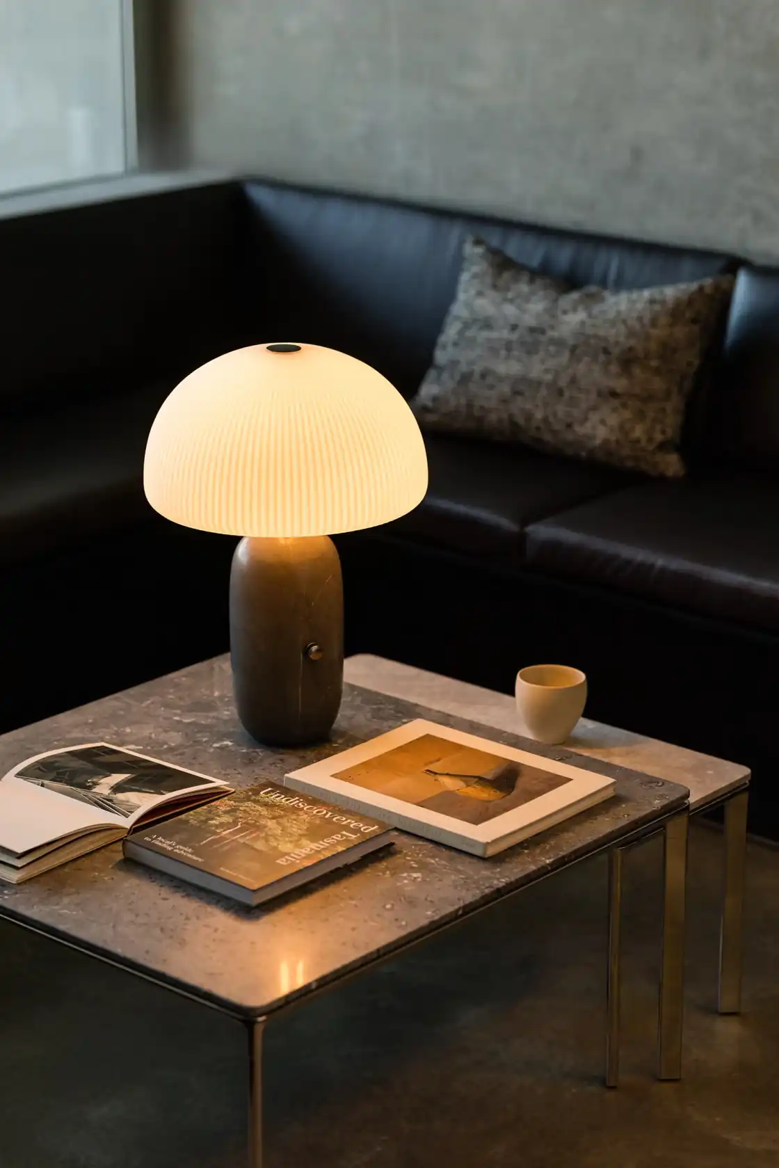 Vipp Sculpture lamp on a square coffee table beside the sunken lounge