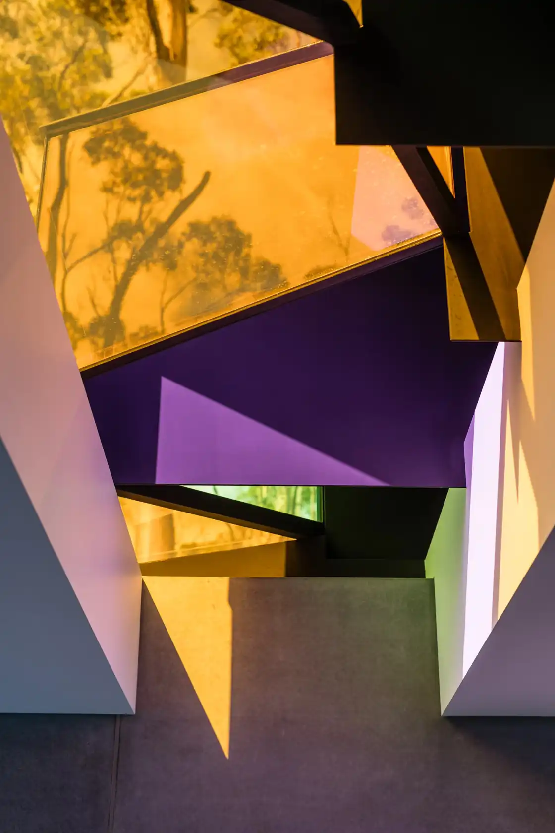 Chromatic skylight glazing casting coloured light across concrete